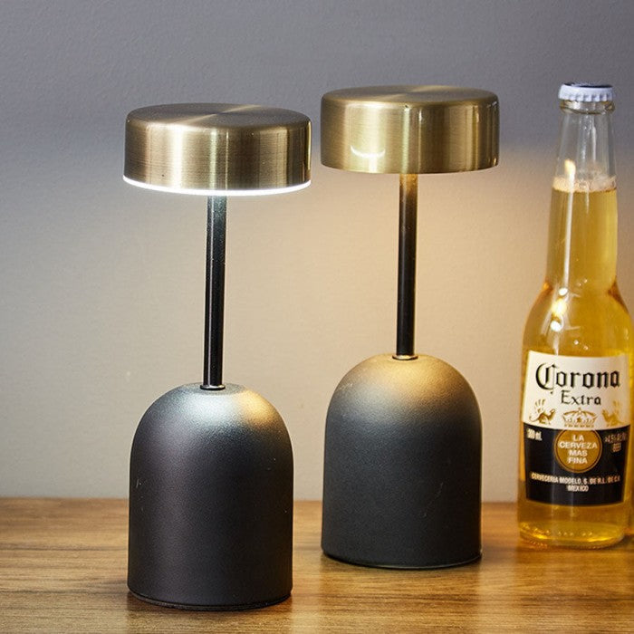 LED-Lampe auf einem Holztisch mit eleganter metallischer Oberfläche.
