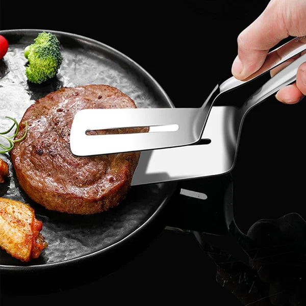 Küchenhelfer beim Wenden eines Steaks auf einem Grill.
