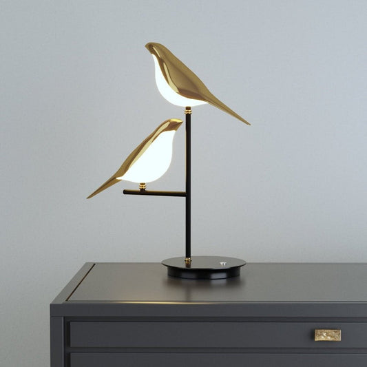 Elegante Tischlampe mit doppelt gestaltetem Vogelmotiv und warmem Licht.
