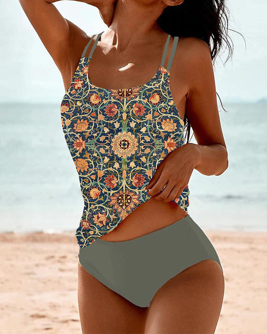 Frau trägt ein elegantes bedrucktes Tankini-Set am Strand.