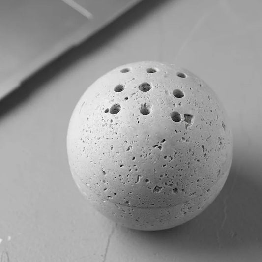 Minimalistisches Räuchergefäß aus Naturstein in runden Händen gehalten.

