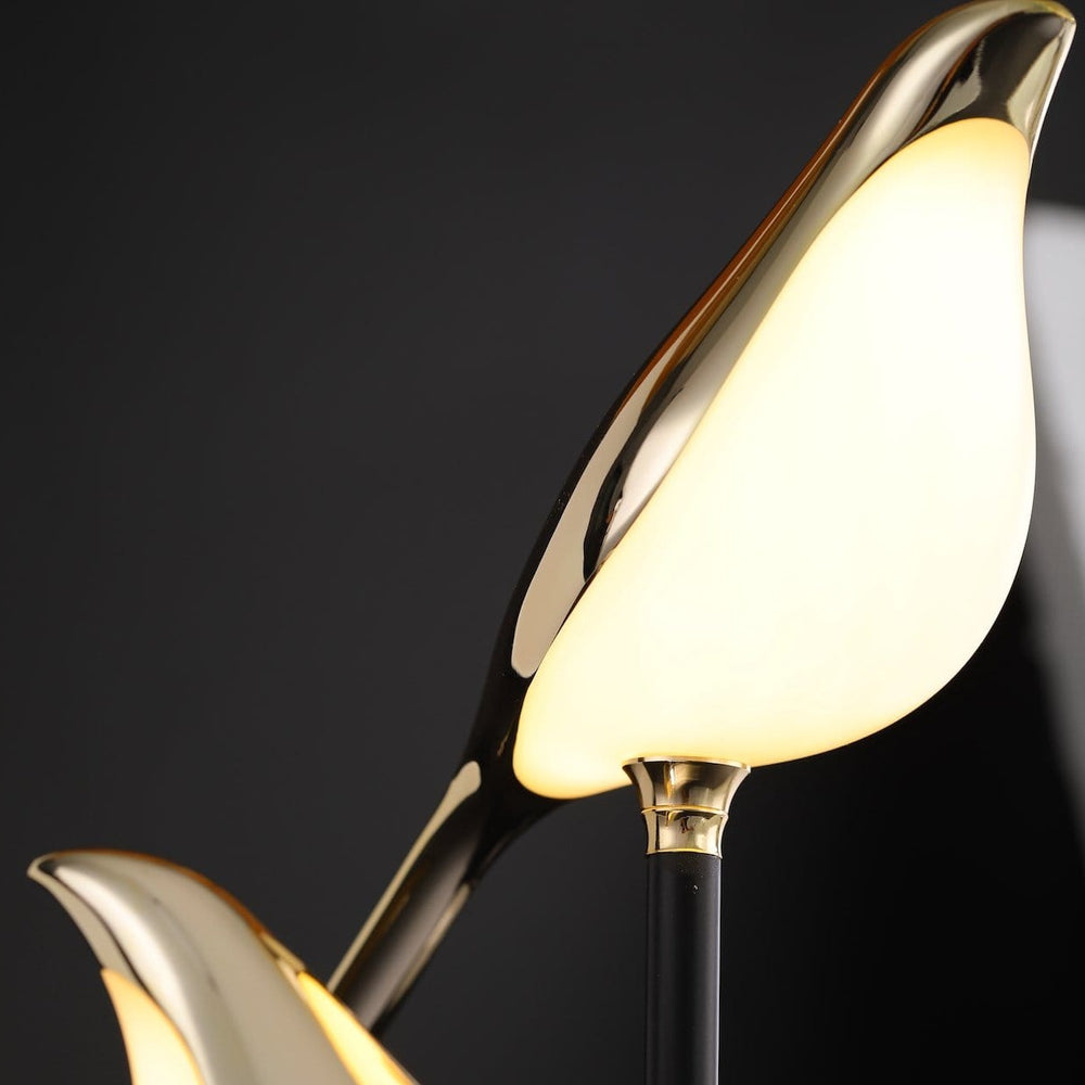 Minimalistische Tischlampe mit eleganten Vogelfiguren und sanftem Licht.