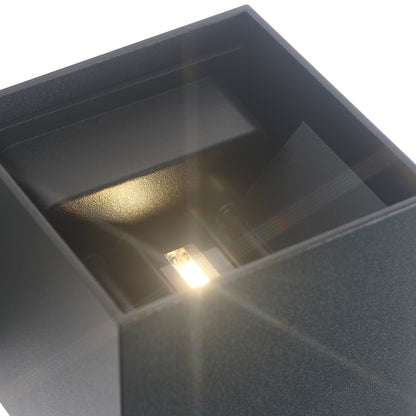 Wandlampe mit warmem Licht und geometrischem Würfeldesign.