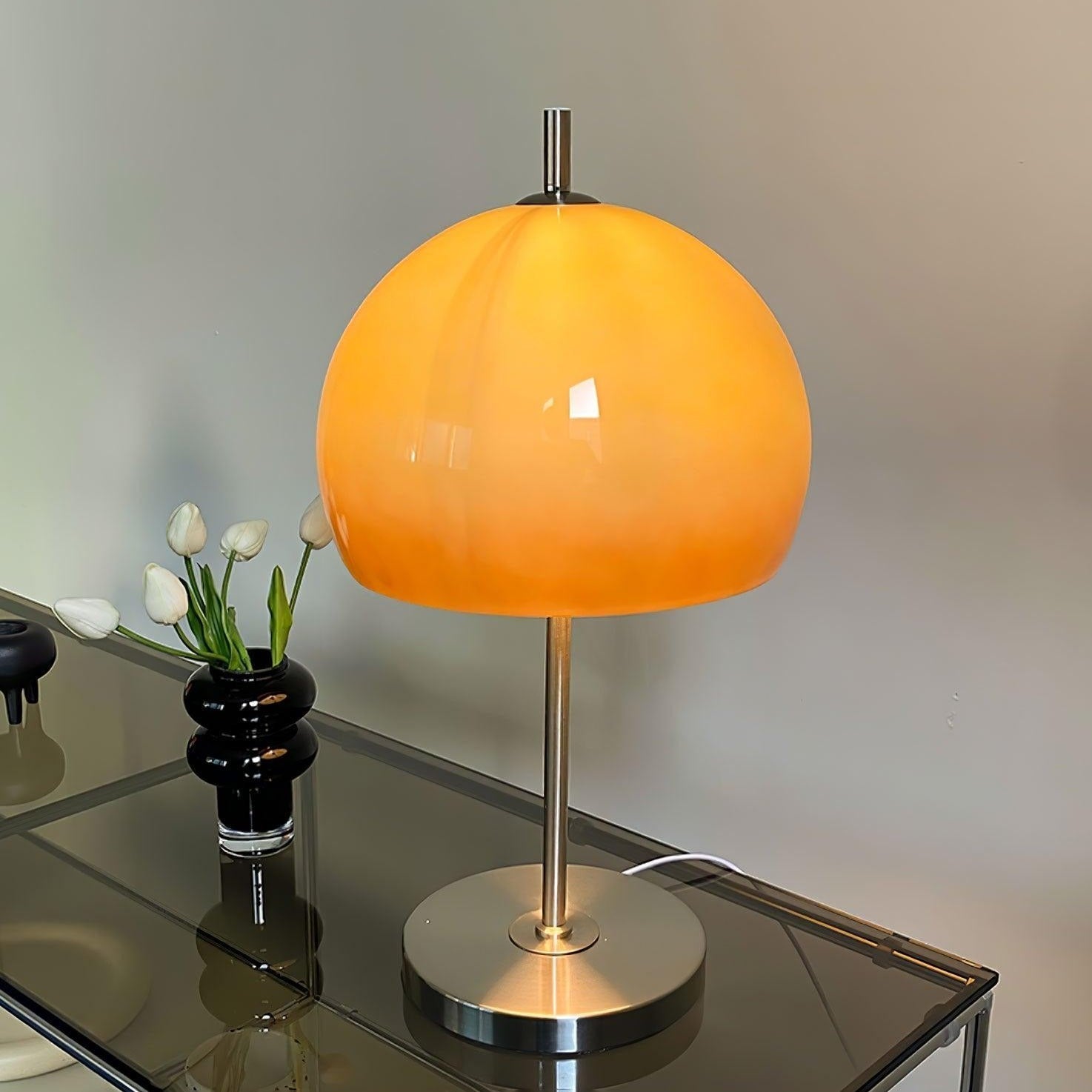 AmberLume Tischleuchte, die in modernen Räumen ein elegantes Licht verströmt.