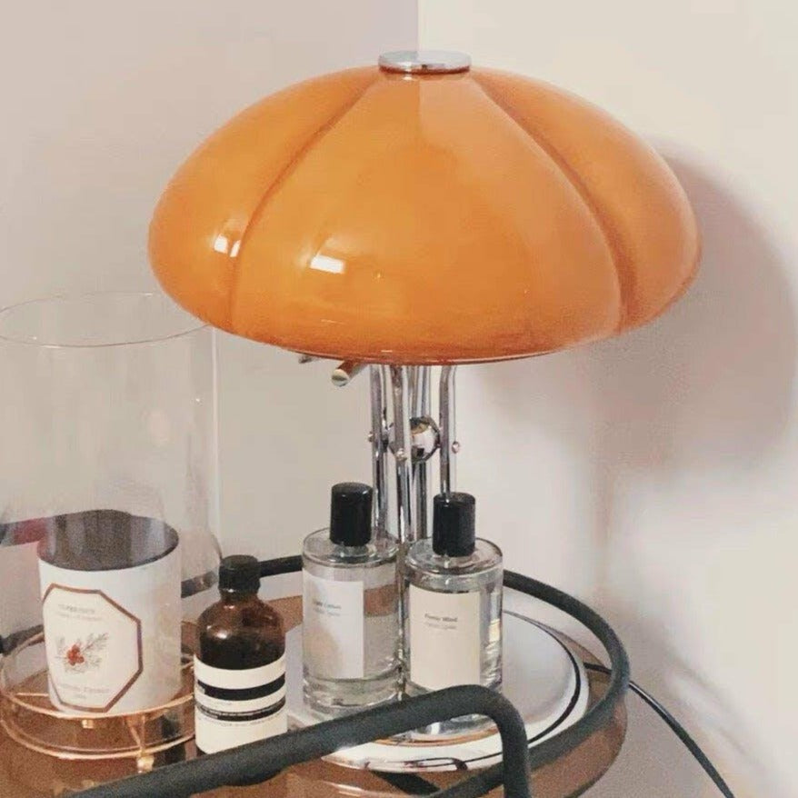 Tischleuchte AmberLume mit glänzendem Fuß und weichem Licht.