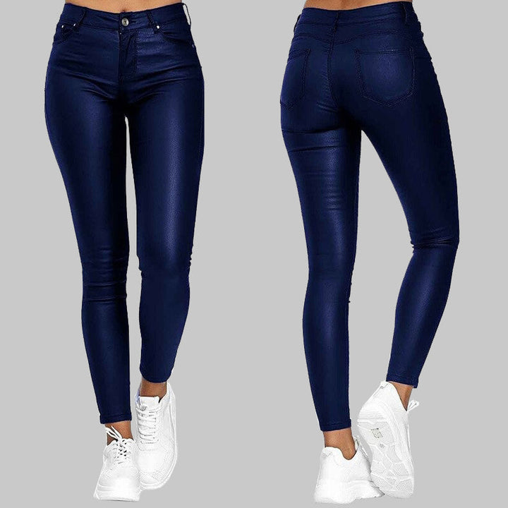 Figurbetonte Lederhose kombiniert mit weißen Sneakers.