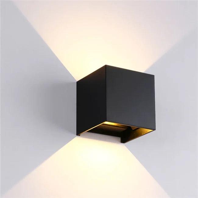 Moderne Wandleuchte im minimalistischen Würfeldesign mit warmem Licht.