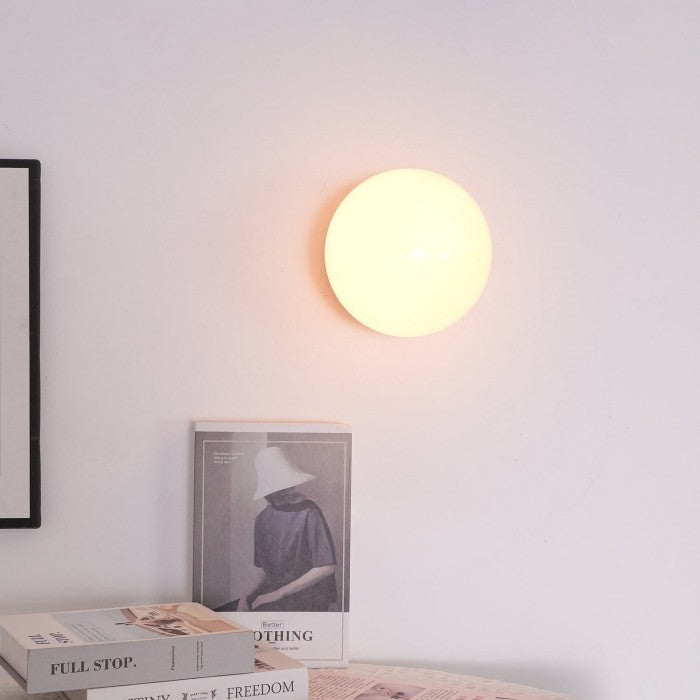 Kugel-Wandleuchte, die sanftes Licht für gemütliche Räume spendet.